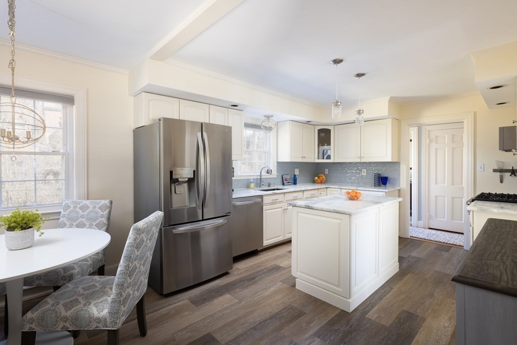 274 Beverly Road Brookline, MA 02467 - Photo 5 of 18 a kitchen with stainless steel appliances granite countertop a refrigerator a stove a sink a dining table and chairs with wooden floor