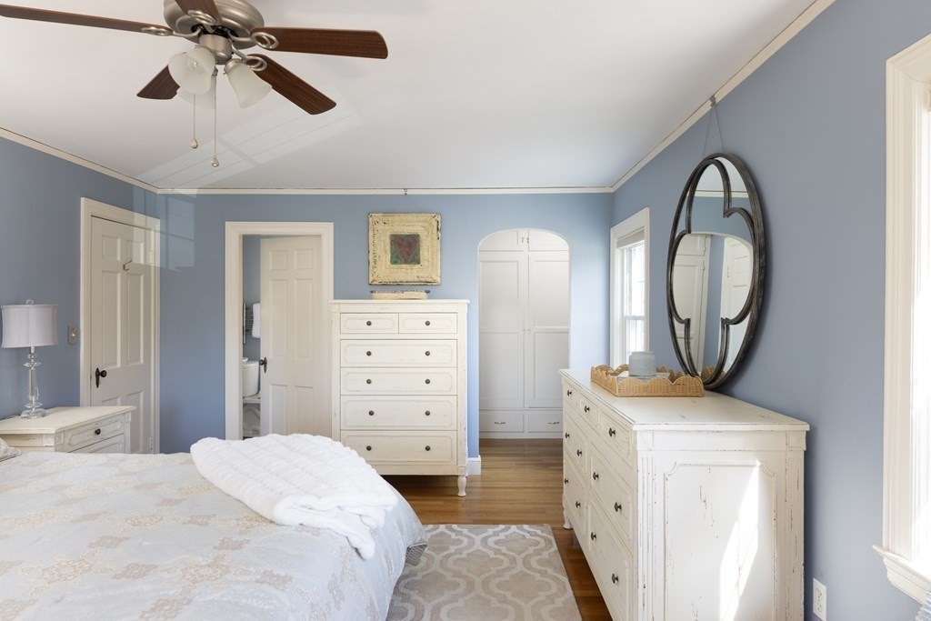 274 Beverly Road Brookline, MA 02467 - Photo 10 of 18 a bedroom with a bed a mirror on dresser and a chandelier