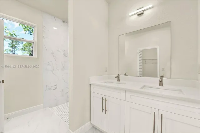 a bathroom with a granite countertop sink a mirror and a shower