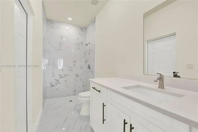 a bathroom with a sink shower and a mirror