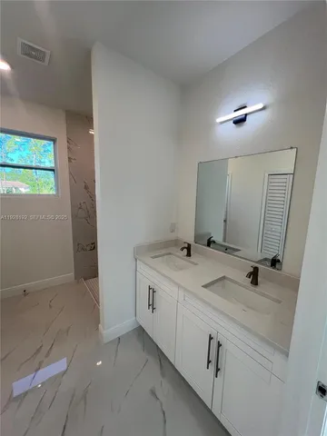 a bathroom with a double vanity sink and a mirror