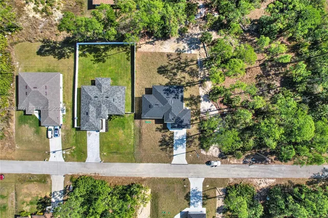 an aerial view of a house with a yard basket ball court and outdoor seating