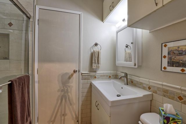 a view of bathroom with a sink mirror and toilet