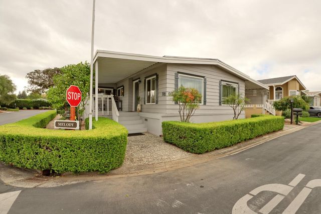 a front view of a house with a garden and plants