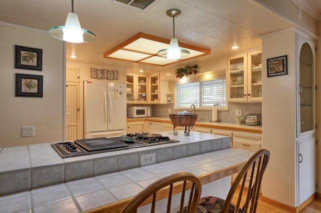 a kitchen with stainless steel appliances granite countertop a stove a refrigerator a oven a sink with a dining table and chairs