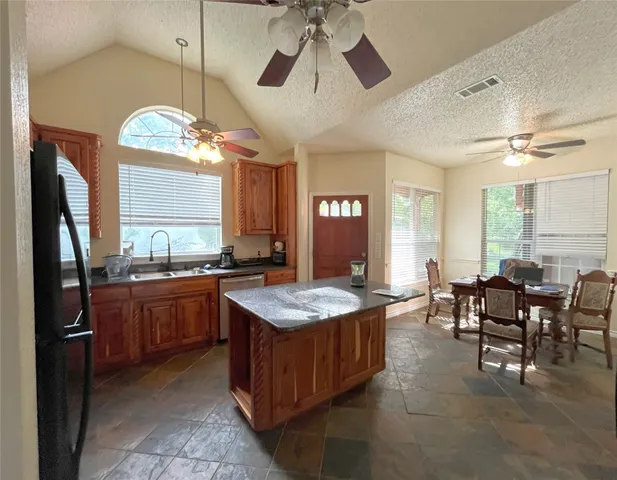 a large kitchen with stainless steel appliances granite countertop a stove a refrigerator a oven with a dining table and chairs