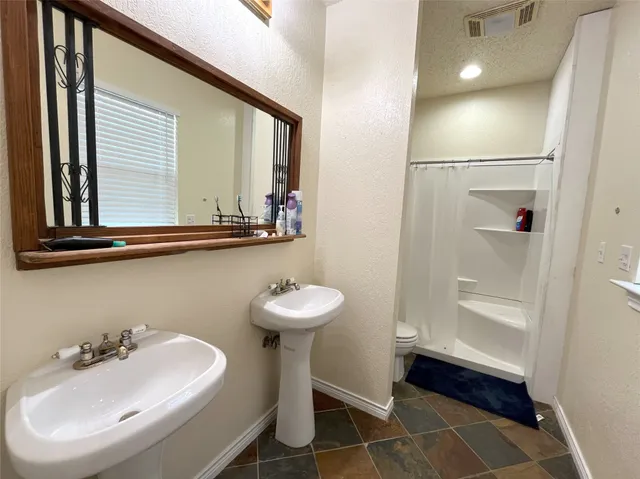 a bathroom with a sink a toilet and a mirror