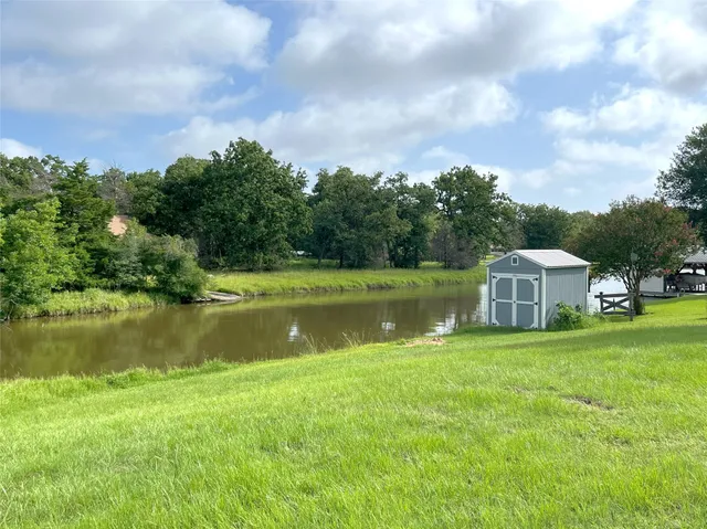 a view of a house with a big yard and a large trees