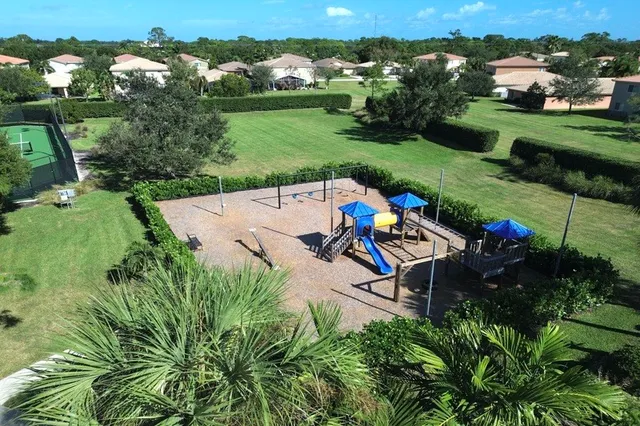 an aerial view of a house with pool big yard and large tree