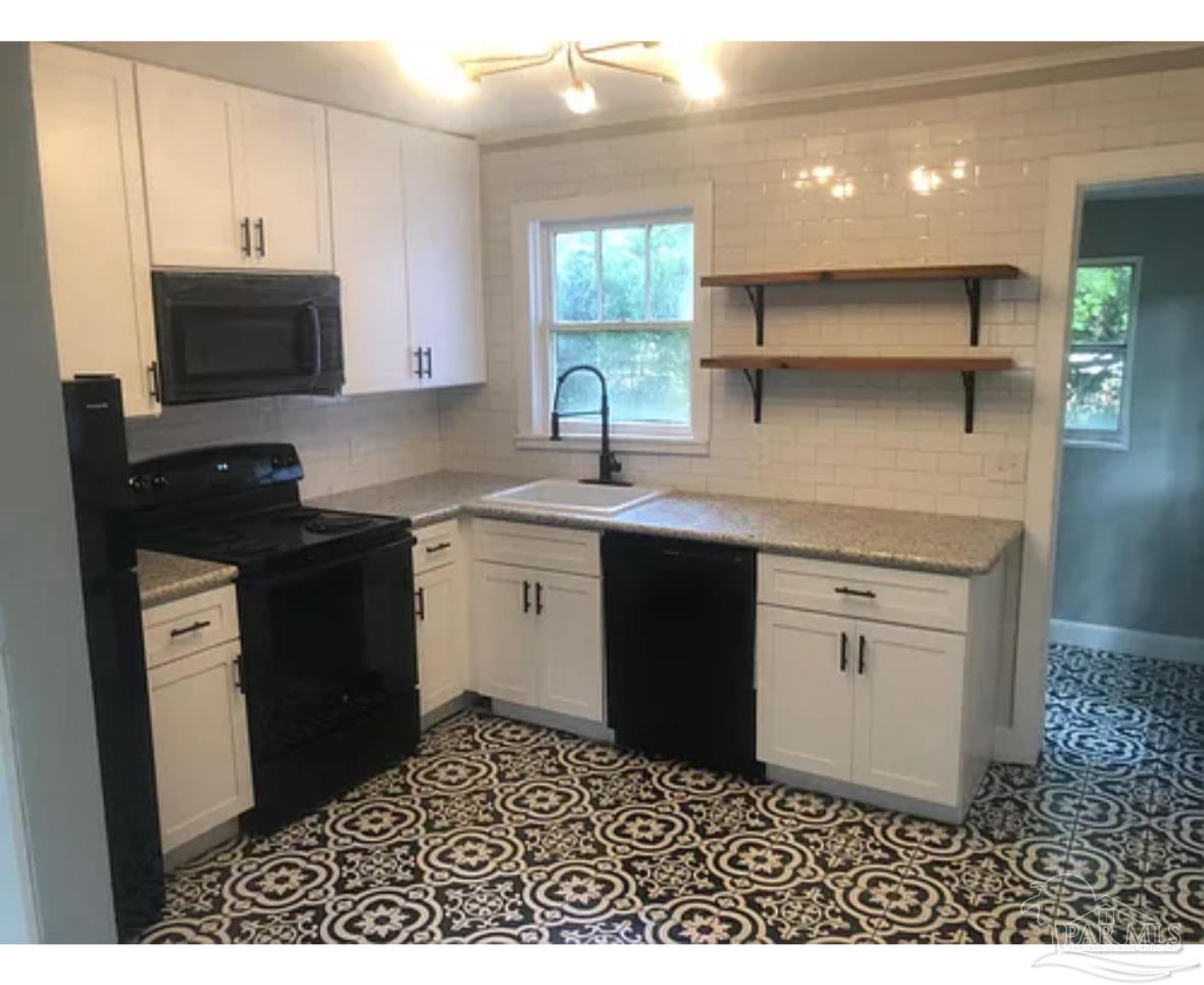3323 West Cervantes Street Pensacola, FL 32505 - Photo 3 of 12 a kitchen with a sink stove and microwave