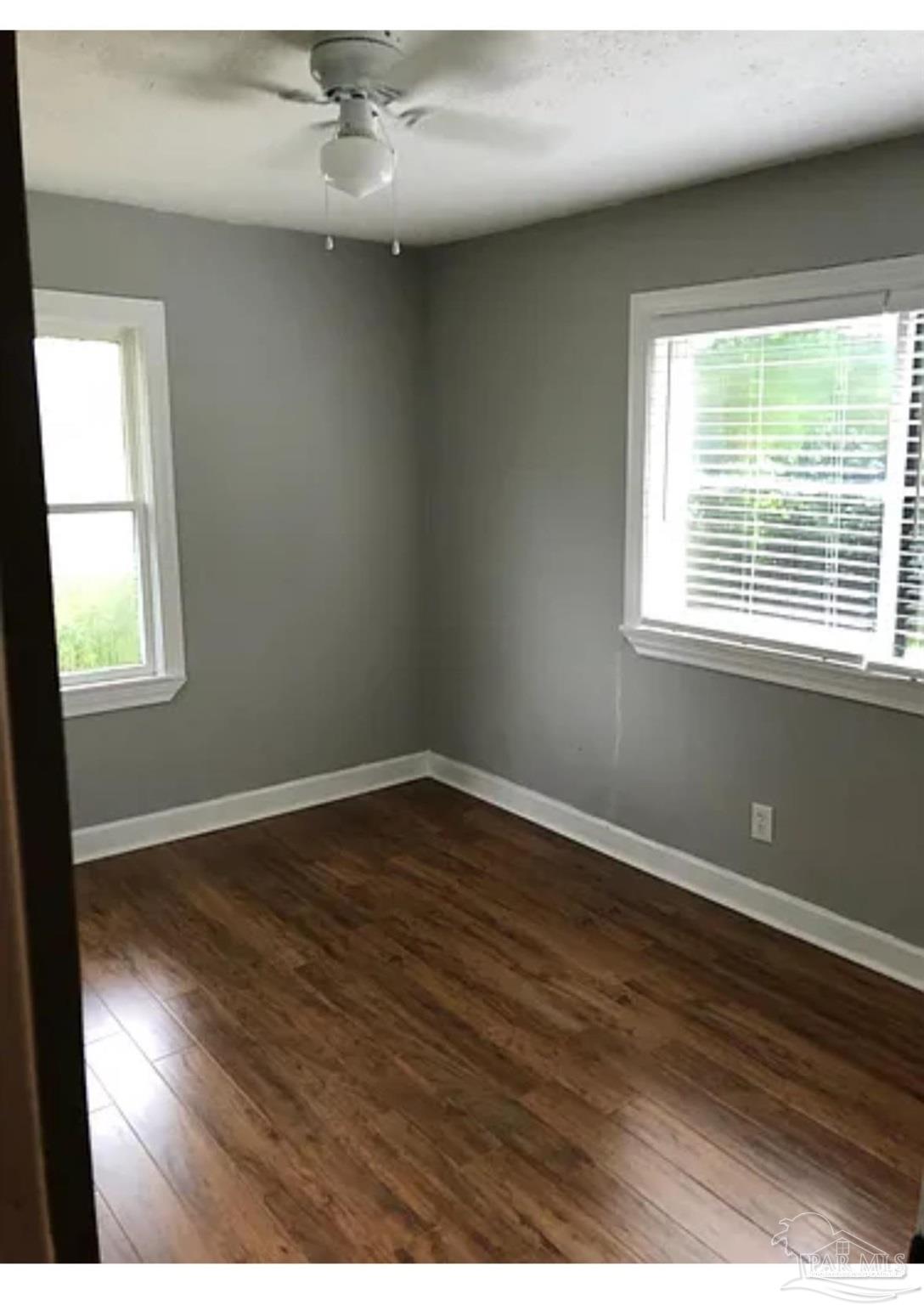 3323 West Cervantes Street Pensacola, FL 32505 - Photo 5 of 12 an empty room with wooden floor and windows