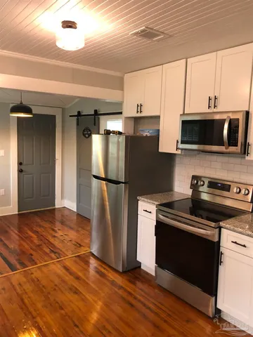 a kitchen with a refrigerator and a stove top oven