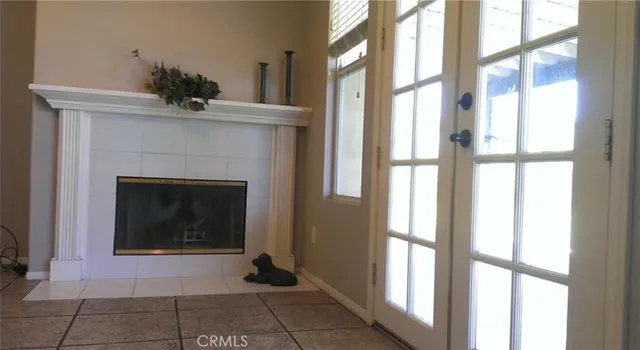a living room with a fireplace and a floor to ceiling window