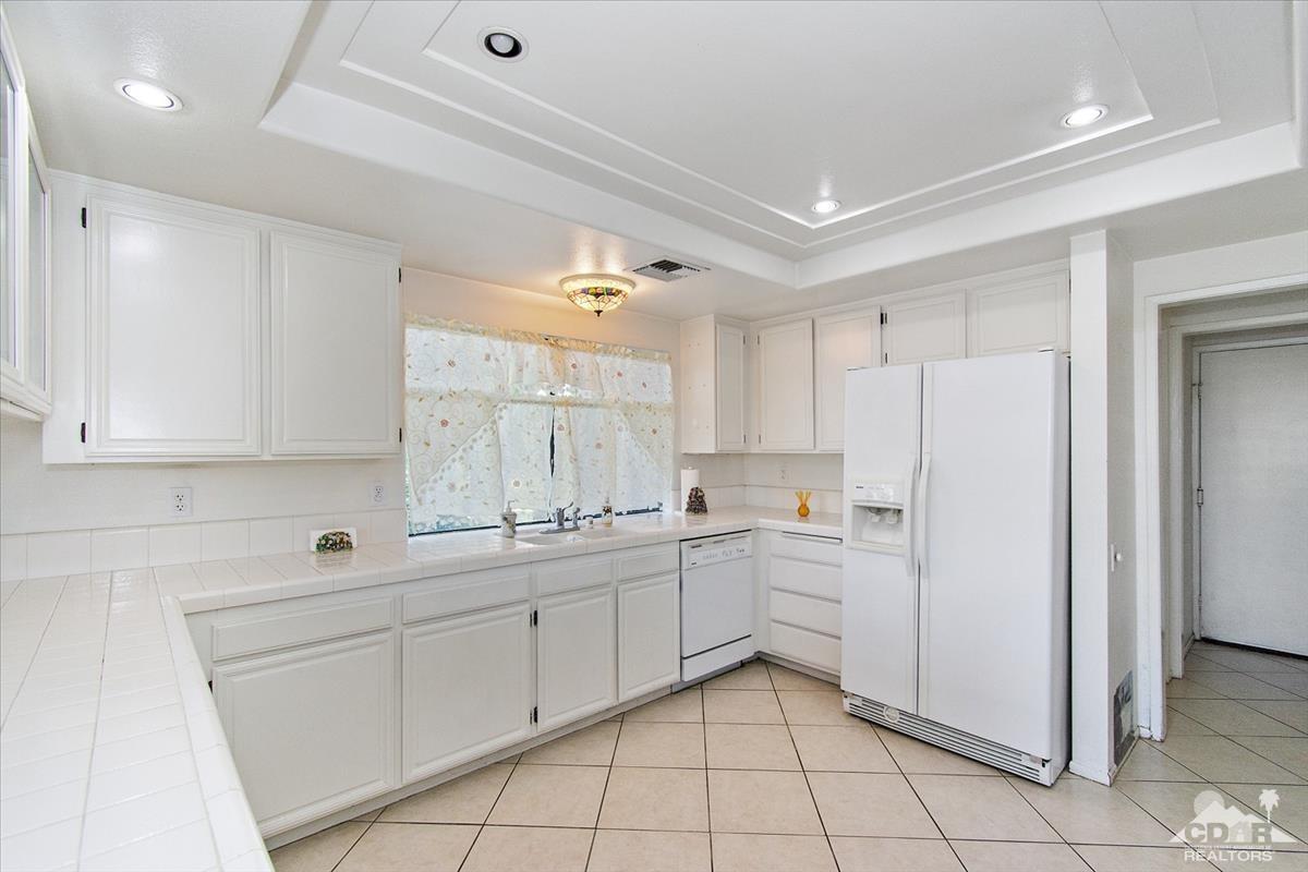 72470 Rodeo Way Rancho Mirage, CA 92270 - Photo 11 of 35 a kitchen with white cabinets and white appliances