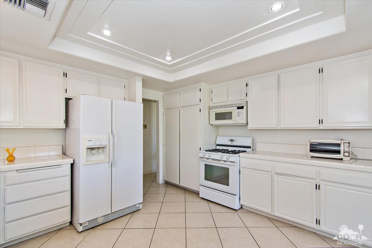 72470 Rodeo Way Rancho Mirage, CA 92270 - Photo 12 of 35 a kitchen with white cabinets and white appliances