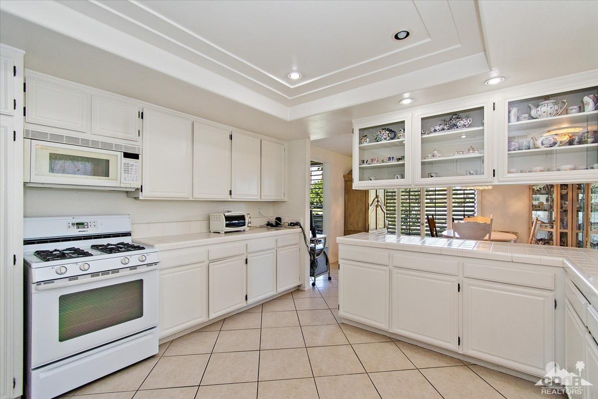 72470 Rodeo Way Rancho Mirage, CA 92270 - Photo 13 of 35 a kitchen with a stove sink and cabinets