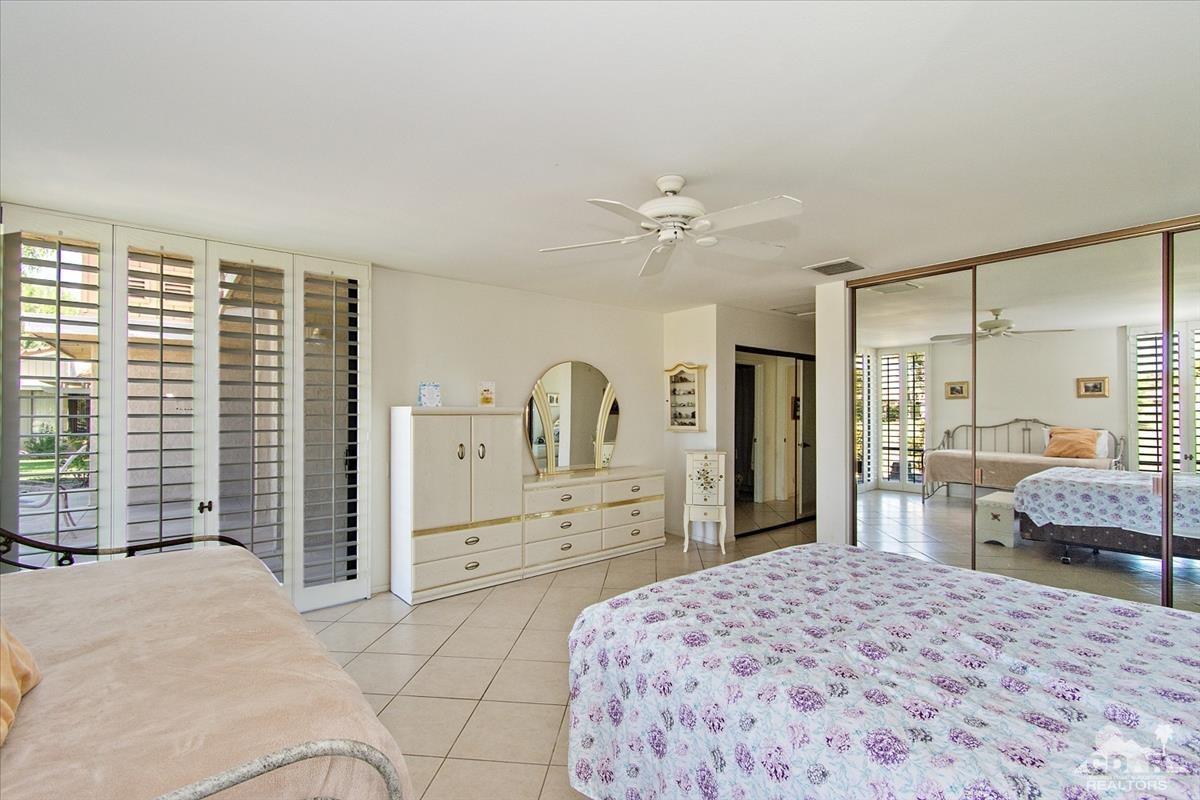 72470 Rodeo Way Rancho Mirage, CA 92270 - Photo 4 of 35 a bedroom with a large bed a chandelier and dresser