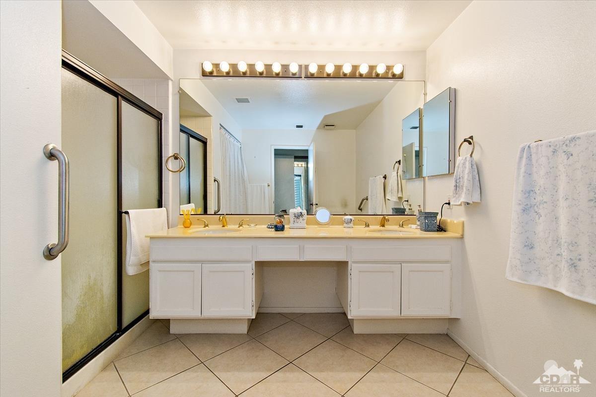 72470 Rodeo Way Rancho Mirage, CA 92270 - Photo 5 of 35 a bathroom with a sink a mirror and a shower