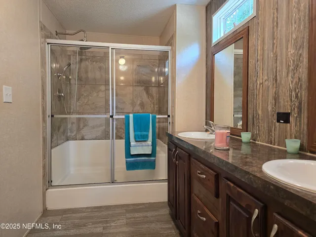 a bathroom with a double vanity sink a mirror and a bathtub