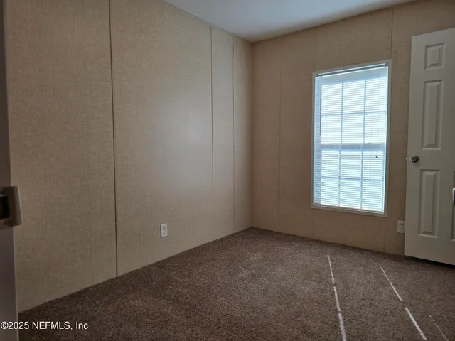 a view of a yard with plants and trees