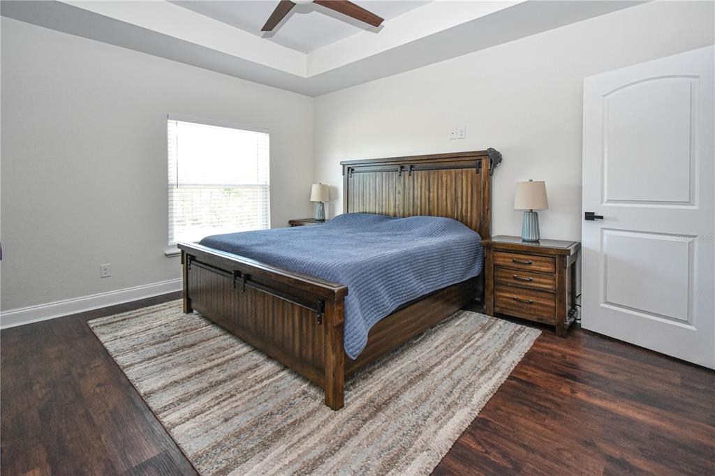 7890 Southwest 129th Avenue Cedar Key, FL 32625 - Photo 18 of 45 a bedroom with a bed and a dresser with wooden floor