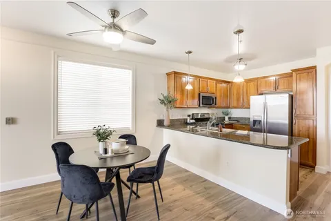 a kitchen with stainless steel appliances a dining table and chairs