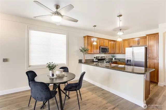 a kitchen with stainless steel appliances a dining table and chairs