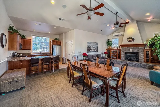 a dining room with furniture a rug a fireplace and a chandelier
