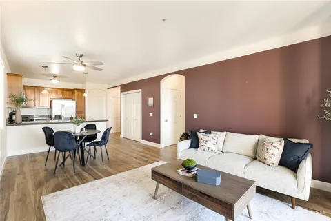 a living room with furniture a wooden floor and a dining table