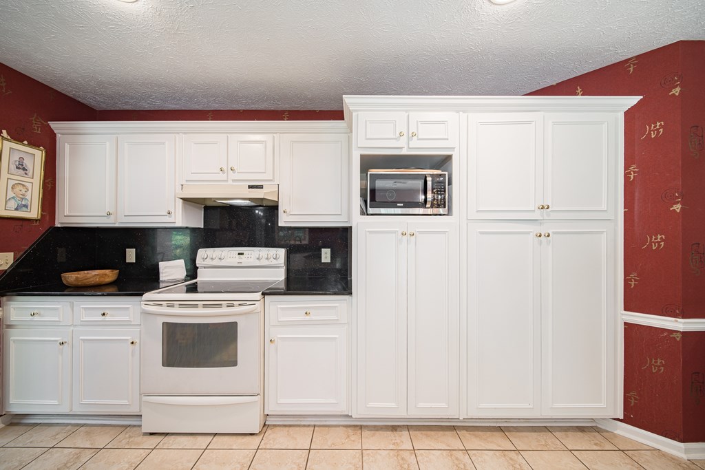 8100 Warm Springs Road Midland, GA 31820 - Photo 11 of 35 a kitchen with white cabinets and white appliances