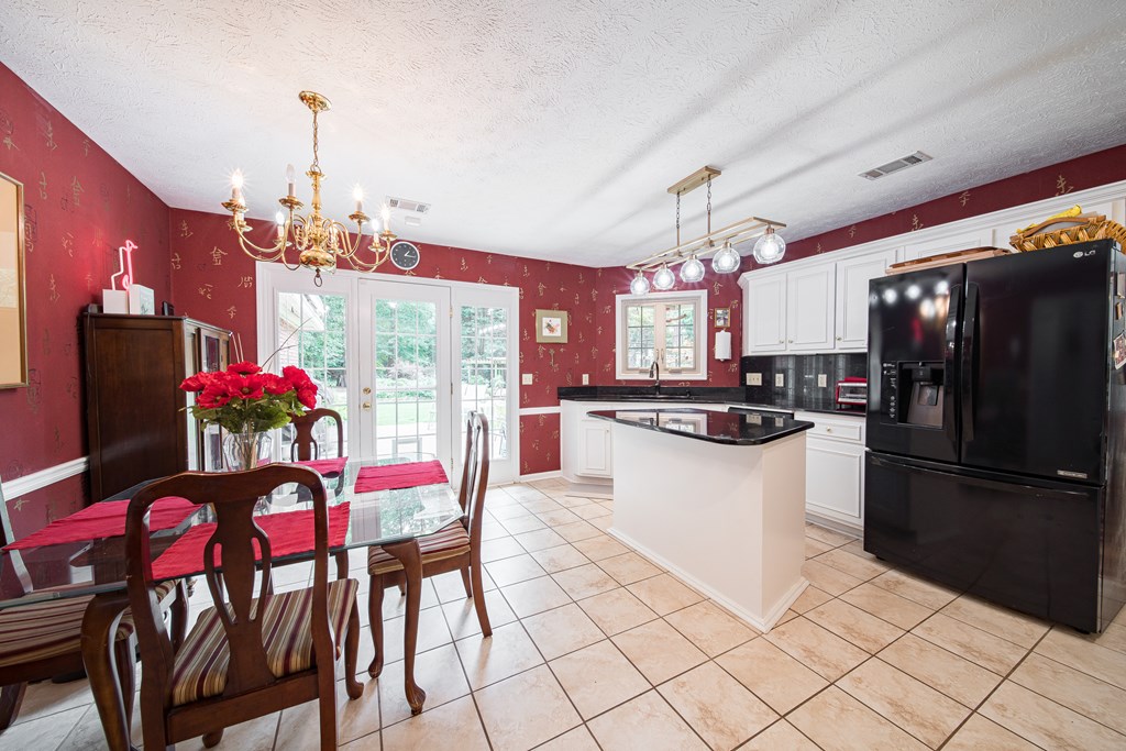 8100 Warm Springs Road Midland, GA 31820 - Photo 13 of 35 a kitchen with stainless steel appliances kitchen island granite countertop a refrigerator a stove a microwave oven a dining table and chairs with wooden floor