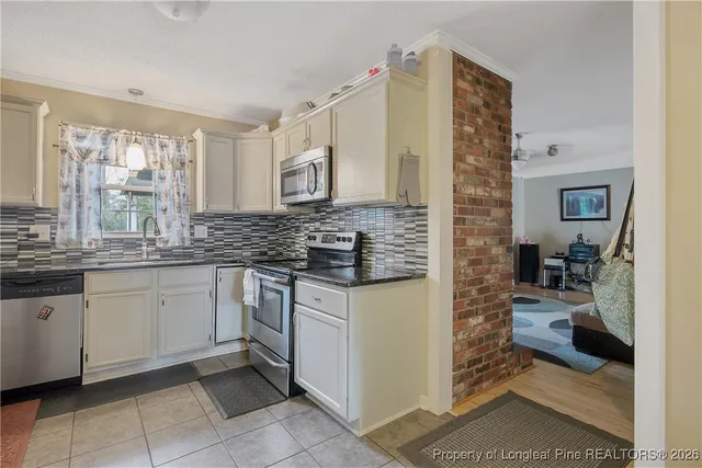 a kitchen with stainless steel appliances granite countertop a stove a microwave and a refrigerator