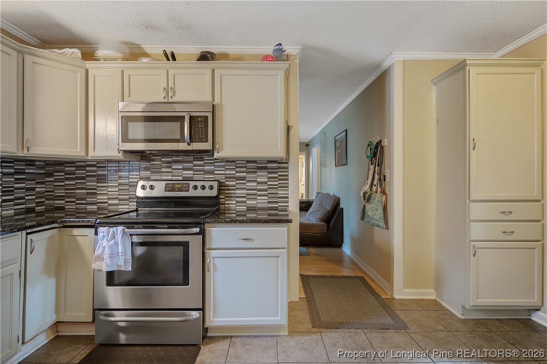 6432 Milford Road Fayetteville, NC 28303 - Photo 18 of 50 a kitchen with stainless steel appliances granite countertop a stove a microwave and a refrigerator
