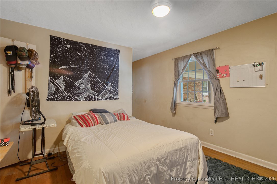 6432 Milford Road Fayetteville, NC 28303 - Photo 28 of 50 a bedroom with a bed and a painting on the wall