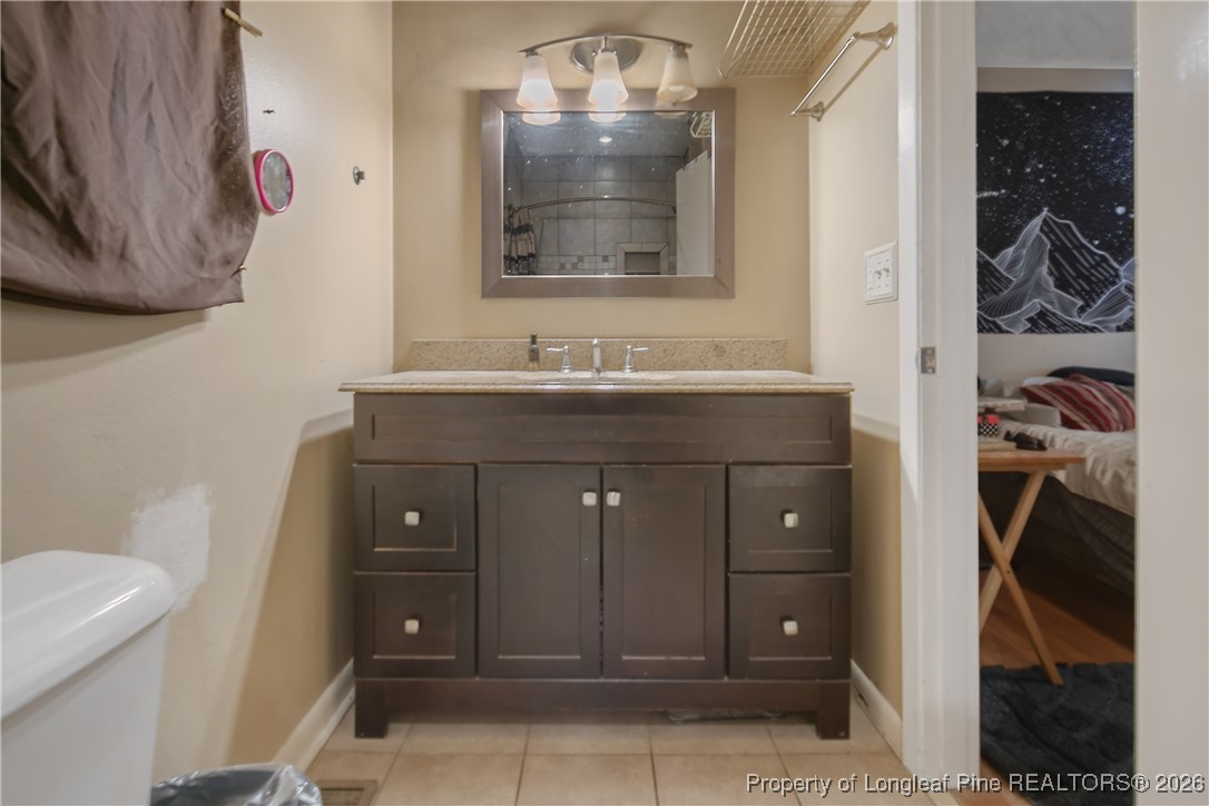 6432 Milford Road Fayetteville, NC 28303 - Photo 31 of 50 a bathroom with a sink a toilet and shower