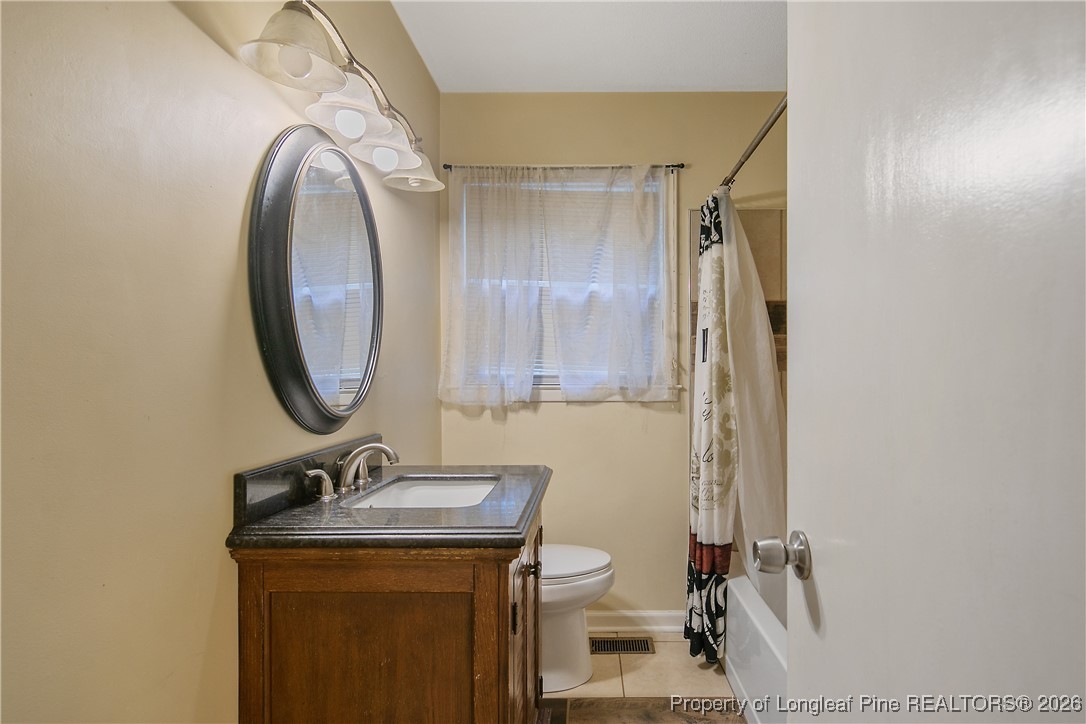 6432 Milford Road Fayetteville, NC 28303 - Photo 36 of 50 a bathroom with a toilet a sink and mirror