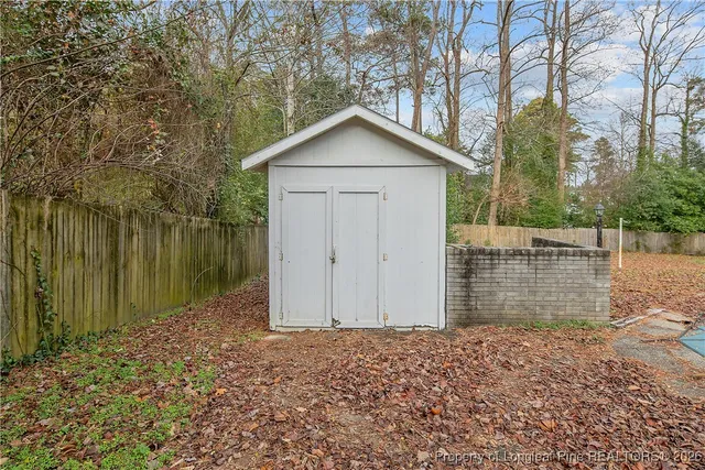 a view of a backyard with table and chairs and a barbeque