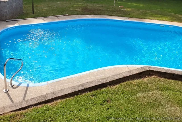 a view of pool with yard and outdoor seating