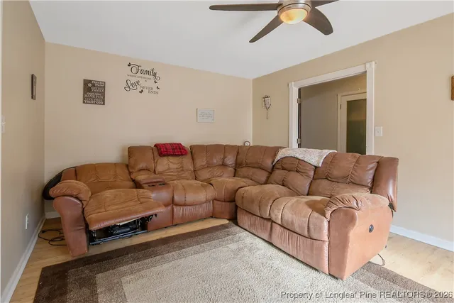 a living room with furniture a ceiling fan and a window