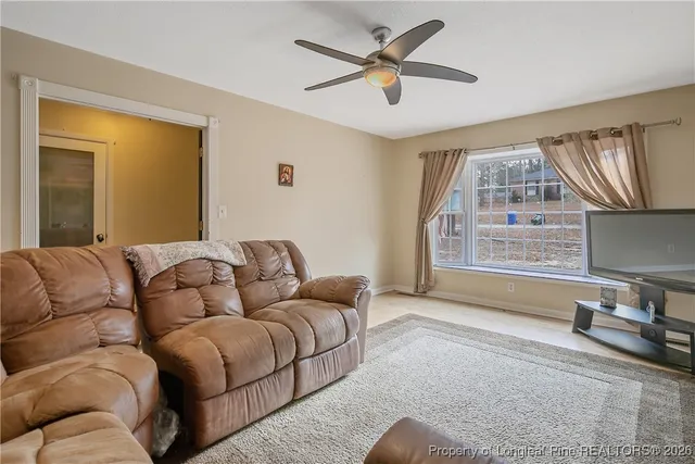 a living room with furniture a window and a flat screen tv