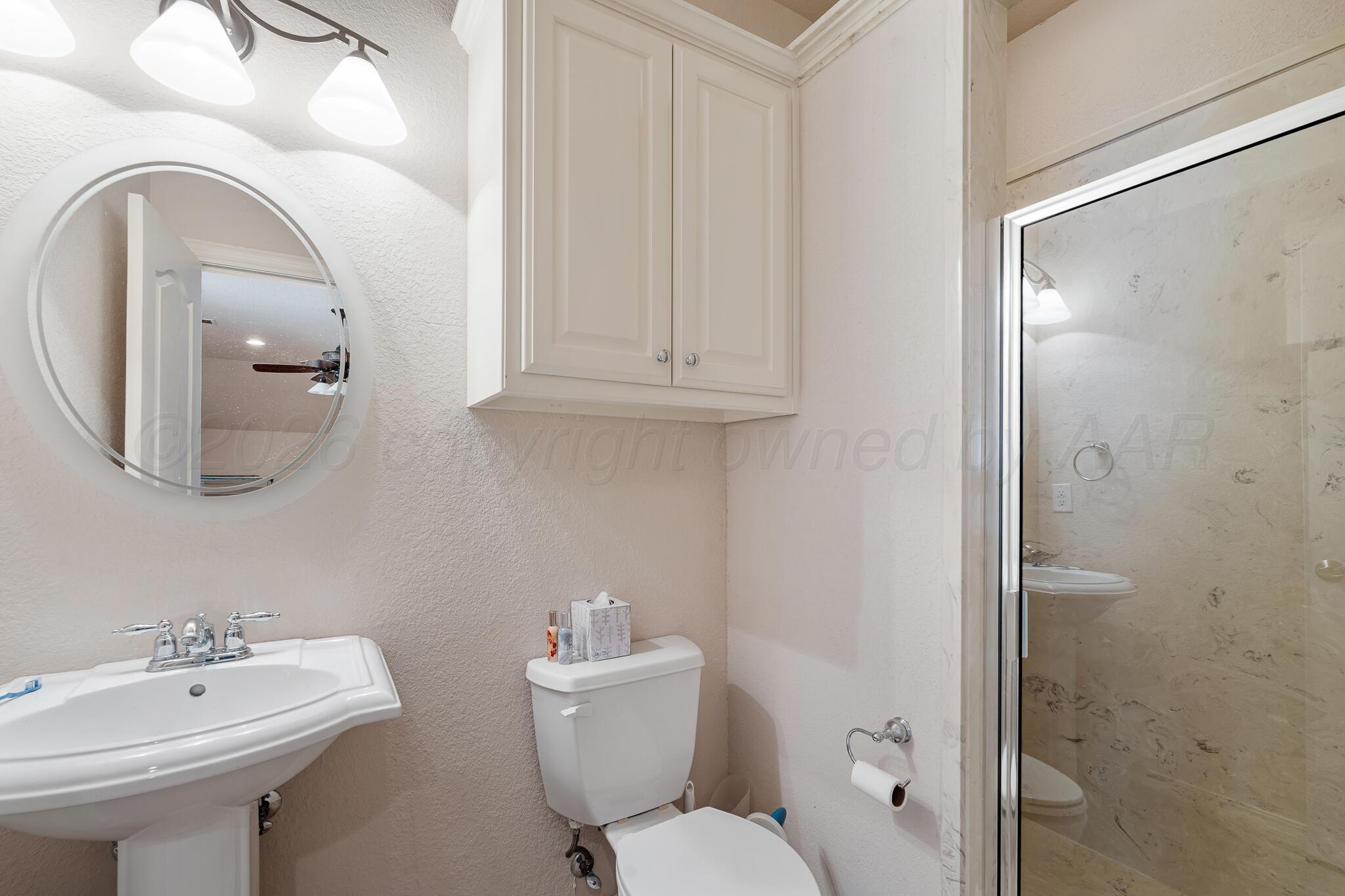 5008 Wesley Road Amarillo, TX 79119 - Photo 17 of 47 a bathroom with a toilet sink and mirror
