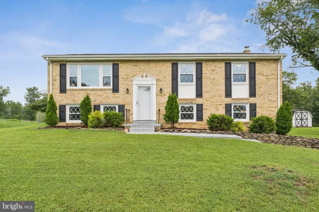 a view of a house with a big yard and large windows