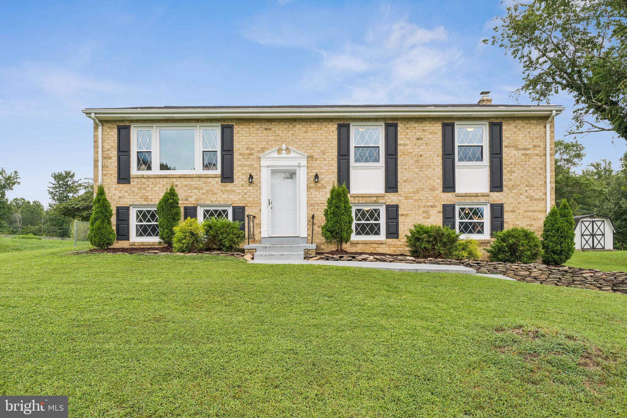a view of a house with a big yard and large windows
