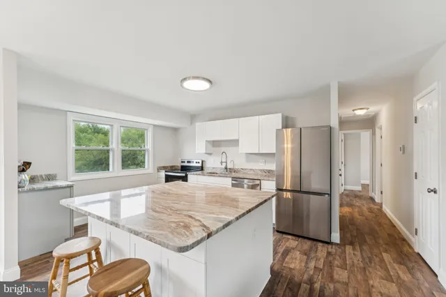 a kitchen with granite countertop a sink appliances a counter space and a window
