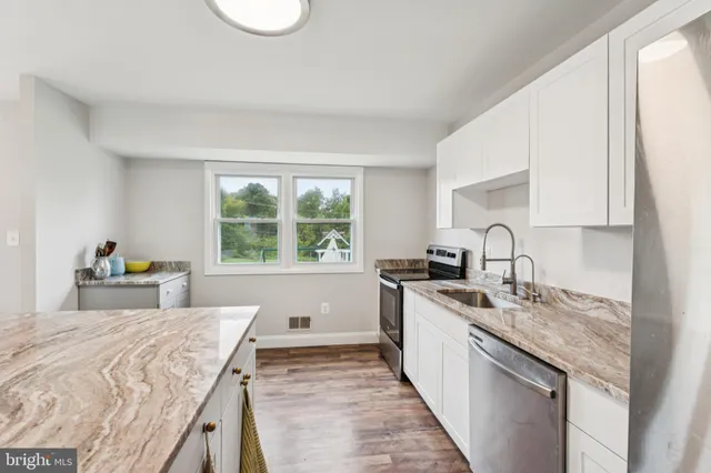 a kitchen with a stove a sink and a cabinets