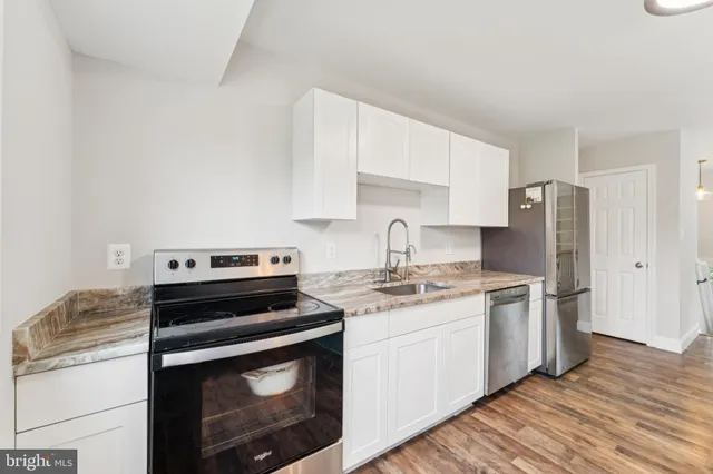 a kitchen with stainless steel appliances a stove a sink and a refrigerator