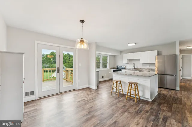 a kitchen with a sink a refrigerator and wooden floor