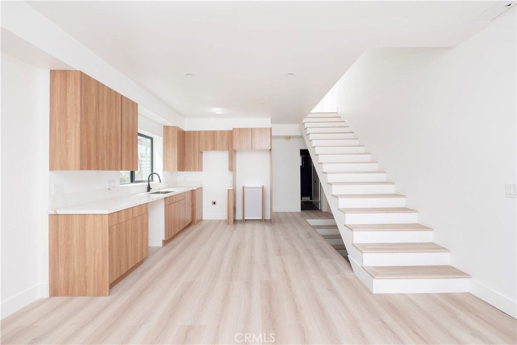 a view of a kitchen with wooden floor and stairs
