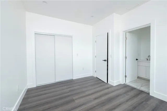 an empty room with wooden floor and entrance