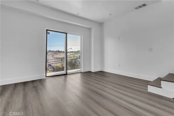 a view of kitchen with wooden floor and electronic appliances